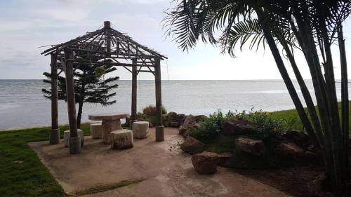 a picnic table and a pavilion next to the ocean at Charm de Chao Lao in Chao Lao Beach
