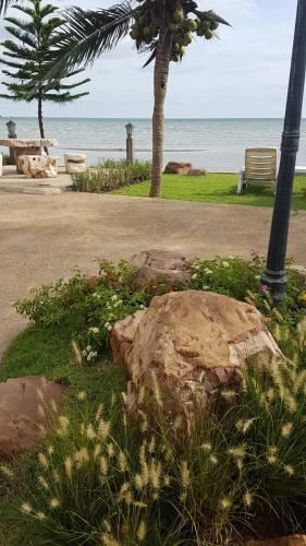 a park with a rock and a tree and the beach at Charm de Chao Lao in Chao Lao Beach