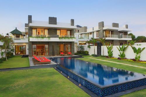 a house with a swimming pool in front of a house at Bali Diamond Estates & Villas in Keramas