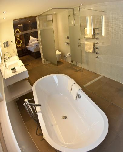 a bathroom with a large white tub and a shower at Stock Apartments in Mayrhofen