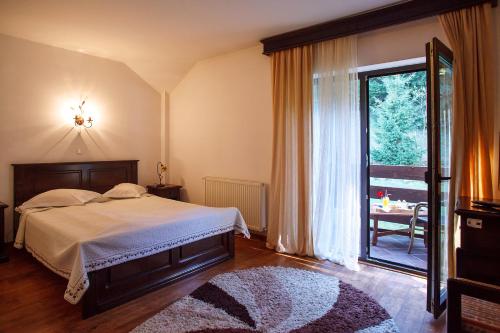 a bedroom with a bed and a large window at Pension Perla Bucovinei in Voronet