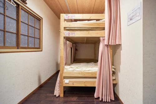 a bunk bed in a room with a window at Osaka Guesthouse Sakura in Osaka