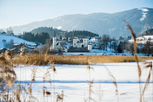 a snow covered field with a town in the background at Haus Goldeggblick in Goldegg