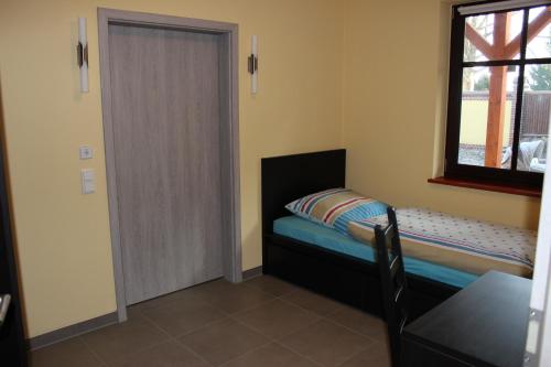 a small bedroom with a bed and a window at L&L Skaters Home in Langenlipsdorf
