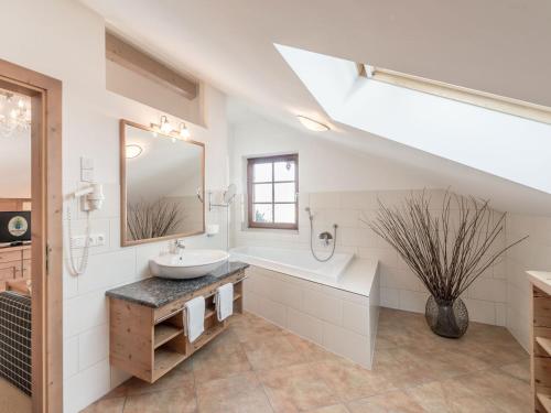 a white bathroom with a sink and a mirror at Schneiderwirt in Nußdorf am Inn
