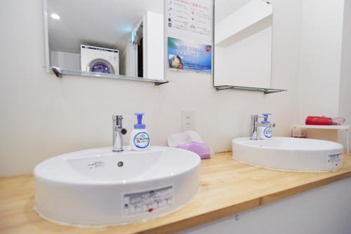 y baño con lavabo blanco y espejo. en Osaka Guesthouse Sakura, en Osaka