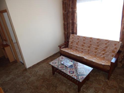 a couch and a table in a room at Гостиница ИЛЕК in Aktobe