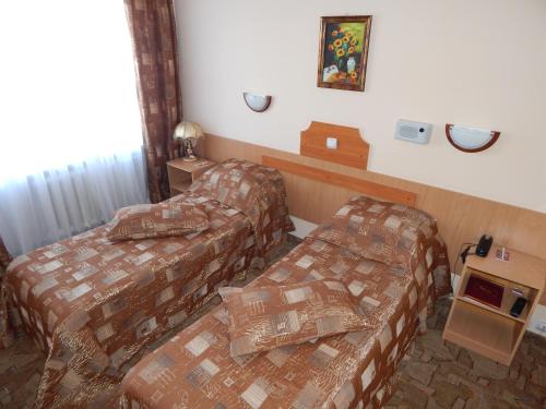 a hotel room with two beds and a tv at Гостиница ИЛЕК in Aktobe