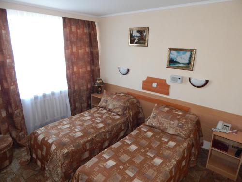 a hotel room with two beds and a window at Гостиница ИЛЕК in Aktobe