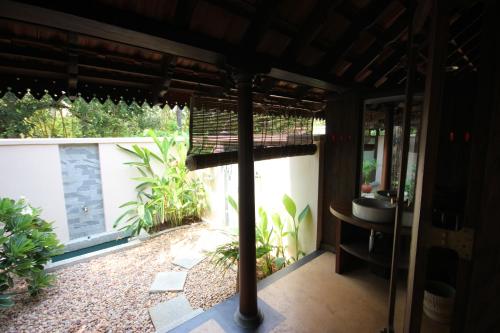 an outside view of a bathroom with a sink and a balcony at Vismaya by Moksha Stays in Turavūr