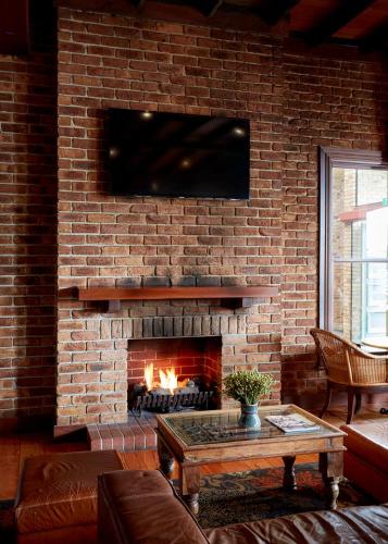a living room with a brick wall with a fireplace at The Terrace at The Settlement in Cranbourne
