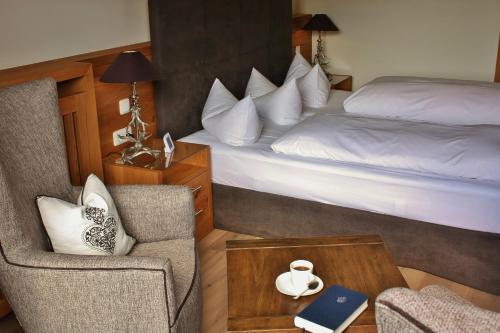 a hotel room with a bed and a chair at Parkhotel am Soier See in Bayersoien