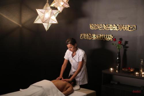 a woman is giving a man a massage at Miramar Hotel Resort and Spa in Trâblous
