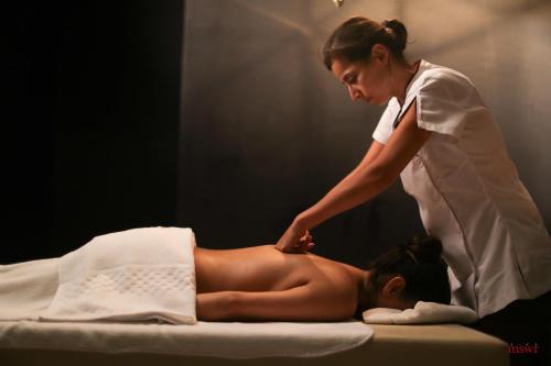a woman is giving a woman a massage at Miramar Hotel Resort and Spa in Trâblous