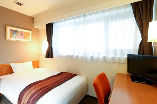 a hotel room with a bed and a window at Hotel Hokke Club Fukuoka in Fukuoka