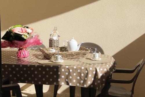 a table with a polka dot table cloth and flowers on it at Le Clos du Square - climatisé in Rochefort