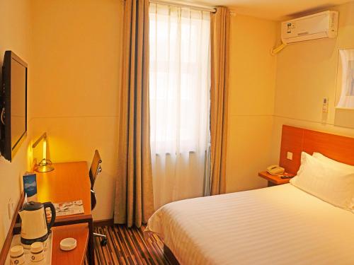 Habitación de hotel con cama y ventana en Goldmet Inn South Loop armed, Datong, en Datong