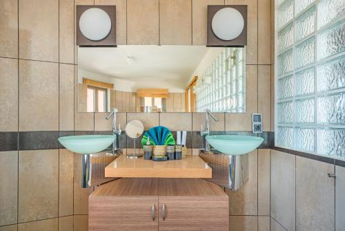 a bathroom with two sinks and a large mirror at Skinos Ilivatos Eco Villa & Estate in Chavriáta
