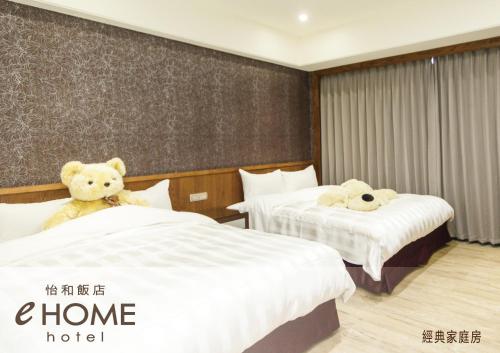 a hotel room with two beds with teddy bears on them at eHome Hotel in Taoyuan