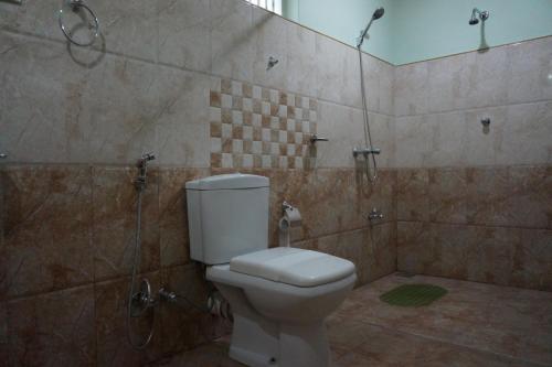 a bathroom with a toilet and a shower at Lake Side Tourist Inn in Tissamaharama