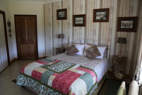 een slaapkamer met een bed met een quilt bij BellbirdHill Bed & Breakfast in Wingham