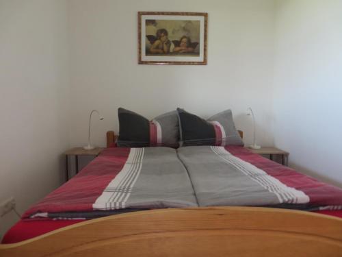 a large bed in a bedroom with a picture on the wall at Ferienwohnung am Golfplatz in Grassau