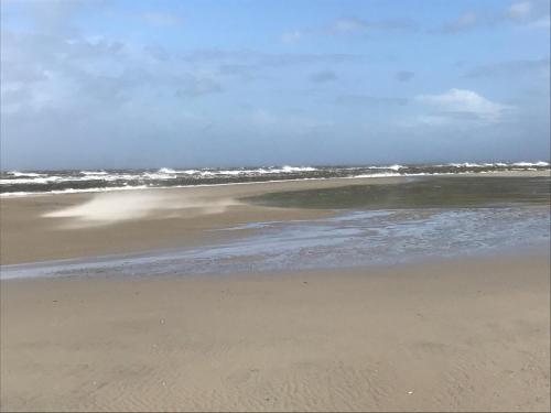 a sandy beach with the ocean in the background at Atlantic Hotel Garni in Wangerooge