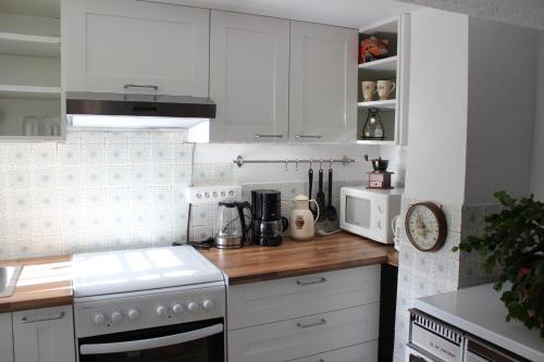 La cuisine est équipée de placards blancs et d'un four avec plaques de cuisson blanches. dans l'établissement chez salome et fritz, à Ingolsheim