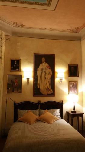 a bedroom with a bed with a painting on the wall at Palazzo Bargellini Panzacchi Apartments in Bologna
