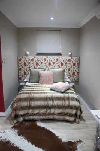a bedroom with a large bed with a large blanket at A' Queenslin Guesthouse in Paarl