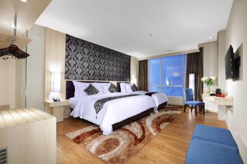 a bedroom with a large bed and a large window at Aston Batam Hotel & Residence in Nagoya