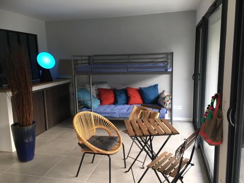 - une chambre avec des lits superposés, une table et des chaises dans l'établissement Appartement Duplex Proche Mer, à Rayol-Canadel-sur-Mer