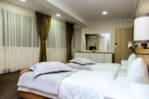a bedroom with two beds and a mirror at Hotel Ildis in Iaşi