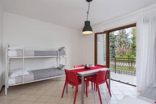 ペスキエーラ・デル・ガルダにあるSan Benedetto di Lugana 2のテーブルと椅子、二段ベッドが備わる客室です。