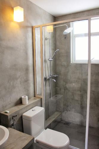 a bathroom with a shower and a toilet and a sink at The Big House in Colombo