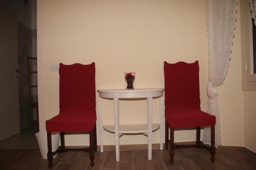 DorioにあるEl Dooradoの白いテーブル(赤い椅子2脚付)、白いテーブル(白いテーブル付)