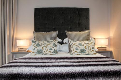 a bedroom with a large bed with two lamps at A' Queenslin Guesthouse in Paarl