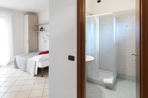 bagno con doccia, letto e lavandino di San Benedetto di Lugana 4 a Peschiera del Garda