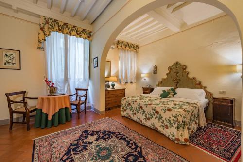 a bedroom with a bed and a table and chairs at B&B Piccolo Hotel in Cortona