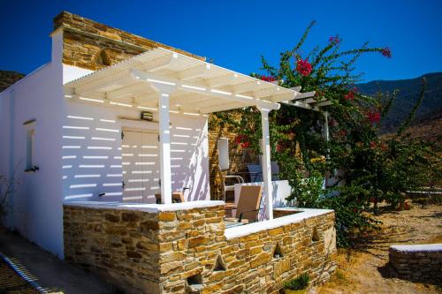 a white pergola on top of a brick wall at Ostria Village in Mylopotas