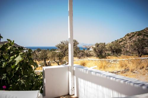 a white fence with a view of the ocean at Ostria Village in Mylopotas