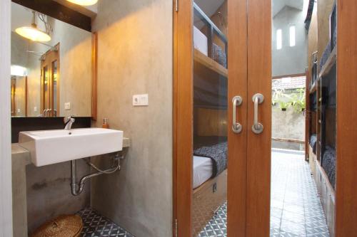 La salle de bains est pourvue d'un lavabo et d'un miroir. dans l'établissement Sunshine Vintage House, à Ubud