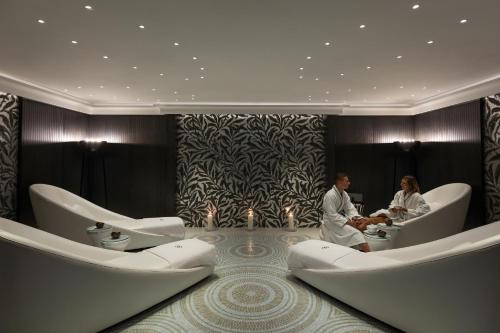 two people sitting in a waiting room with toilets at Sofitel Frankfurt Opera in Frankfurt/Main