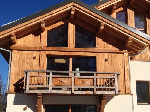 a house with a wrap around porch with a deck at Chalet ChampBenoit in Valmorel