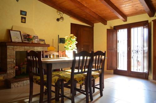 comedor con mesa, sillas y chimenea en La Stella Del Pollino, en San Lorenzo Bellizzi