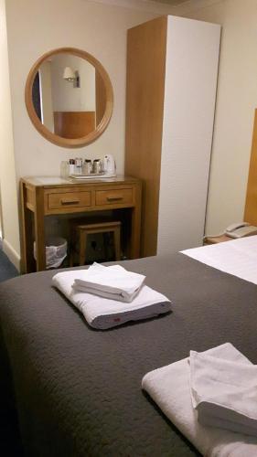 a bathroom with a mirror and a bed and a sink at George Oxford Hotel in Oxford