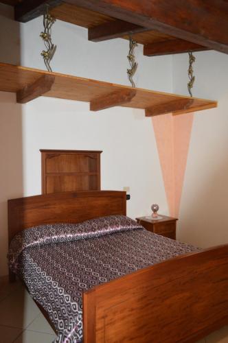 a bedroom with a wooden bed in a room at La Stella Del Pollino in San Lorenzo Bellizzi