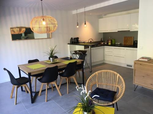 レイヨル・カナデル・シュル・メールにあるAppartement Duplex Proche Merのテーブルと椅子のあるキッチンとダイニングルーム