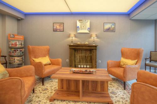 a waiting room with orange chairs and a table at Anna Hotel in Budapest