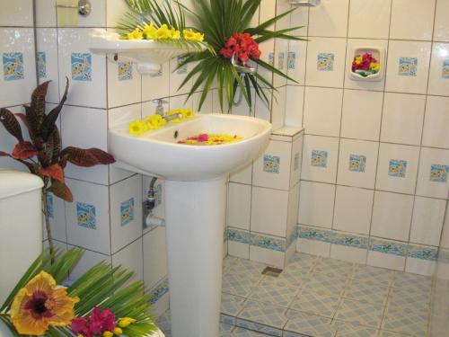 ein Badezimmer mit einem Waschbecken mit Blumen darauf in der Unterkunft Villa Kissen in Trou aux Biches